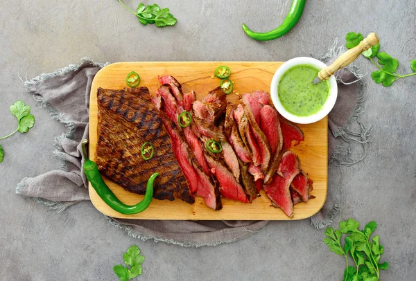 Flank steak on a wooden cutting board