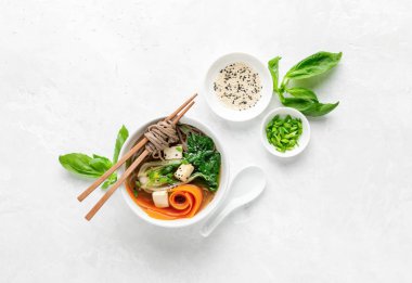 Bok choy ve tofu vejetaryen udon çorbası soğan ve susam tohumlu, yukarıdan görünüyor.