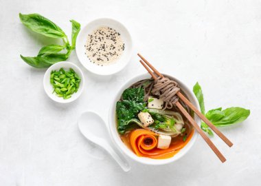 Bok choy ve tofu vejetaryen udon çorbası soğan ve susam tohumlu, yukarıdan görünüyor.