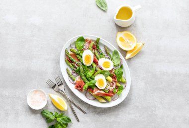 Bahar proteini zengin kuşkonmaz salatası jamon dilimleri ve haşlanmış yumurtalar mevsimsel sağlıklı yemek tarifi fikri, tepeden tırnağa görüş.