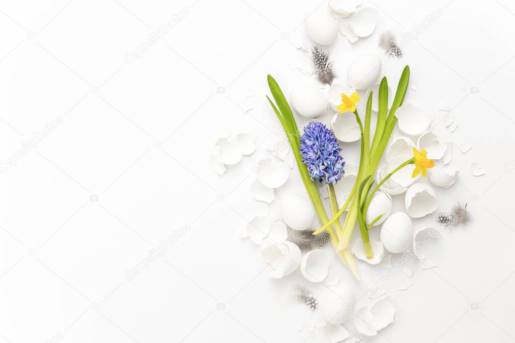 Easter greeting card or flyer background, spring festive composition of flowers eggs and egg shell lying flat with blank space for a text