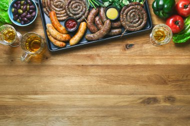 Domates sosu, hardal ve bira ile servis edilen sosisler, yaz partisi aşçılık fikri, yukarıdan aşağıya görüş, mesaj için boş alan