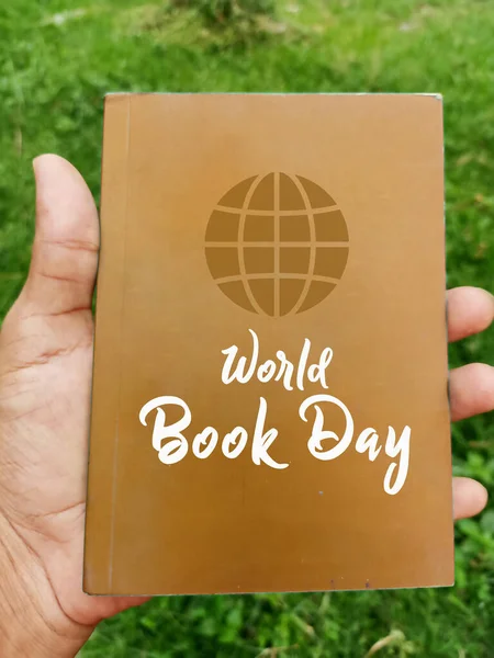 World book day concept. Find your world with the book. Book holding creatively with nature background. World literature concept, 23rd march World book day.