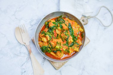 Ayam Woku veya Tavuk woku / Baharatlı Basil Chicken, Manado 'da yetişen bir Endonezya yemeğidir..