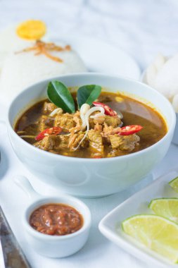 Rawon geleneksel Endonezya sığır eti siyah çorbasıdır. Haşlanmış pirinç, tuzlu yumurta, fasulye filizi, sambal ve krupuk (karides krakeri) ile servis edilir.)