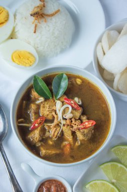 Rawon geleneksel Endonezya sığır eti siyah çorbasıdır. Haşlanmış pirinç, tuzlu yumurta, fasulye filizi, sambal ve krupuk (karides krakeri) ile servis edilir.)