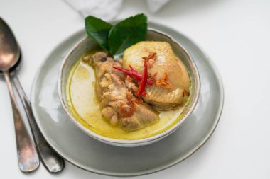 Opor Ayam (Endonezya Köri Tavuğu), Hindistan cevizi sütü ve baharatlarla pişirilmiş tavuk ve Idul Fitri / Lebaran 'ı buharlı pirinçle kutlamak için servis edilmiştir. 