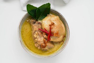 Opor Ayam (Endonezya Köri Tavuğu), Hindistan cevizi sütü ve baharatlarla pişirilmiş tavuk ve Idul Fitri / Lebaran 'ı buharlı pirinçle kutlamak için servis edilmiştir. 