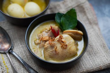 Opor Ayam (Endonezya köri), hindistan cevizi sütü ve baharatında pişirilmiş tavuk ve yumurta ve Idul Fitri / Lebaran 'ı buharlı pirinçle kutlamak için servis edildi. 