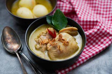 Opor Ayam (Endonezya köri), hindistan cevizi sütü ve baharatında pişirilmiş tavuk ve yumurta ve Idul Fitri / Lebaran 'ı buharlı pirinçle kutlamak için servis edildi. 