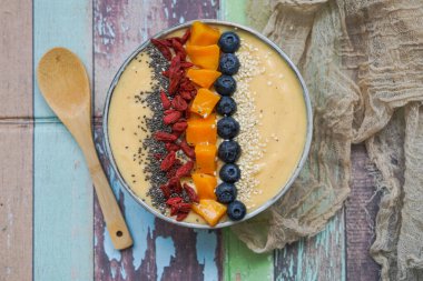 Mango, muz, kivi ve yoğurttan yapılmış taze mangolu smoothie kasesi.