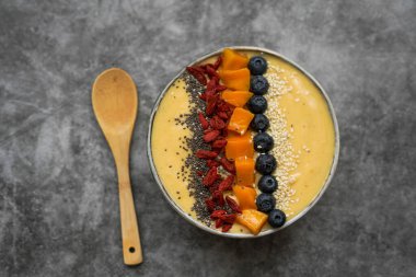 Mango, muz, kivi ve yoğurttan yapılmış taze mangolu smoothie kasesi.