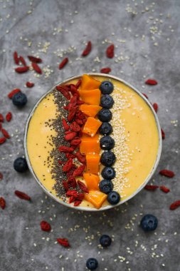 Mango, muz, kivi ve yoğurttan yapılmış taze mangolu smoothie kasesi.