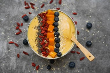 Mango, muz, kivi ve yoğurttan yapılmış taze mangolu smoothie kasesi.