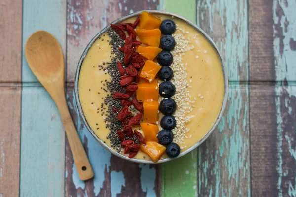 Fresh mango smoothie bowl made from mango, banana, kiwi and yogurt, selective focus