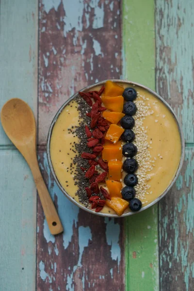 Fresh mango smoothie bowl made from mango, banana, kiwi and yogurt, selective focus