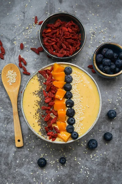 Fresh mango smoothie bowl made from mango, banana, kiwi and yogurt, selective focus