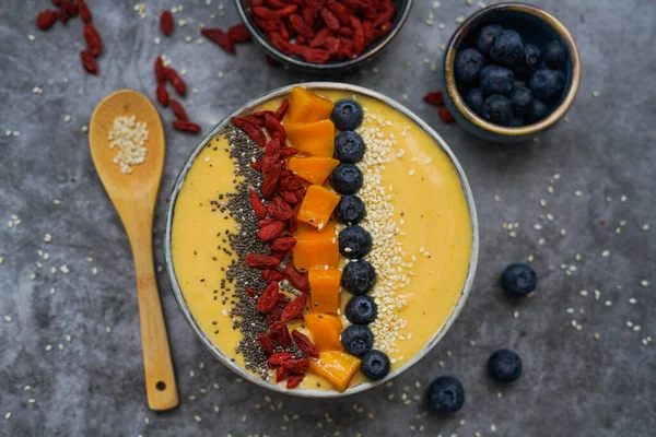 Fresh mango smoothie bowl made from mango, banana, kiwi and yogurt, selective focus