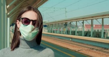 Tren istasyonunda maskeli bir kadın.