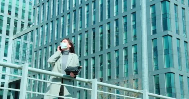 ビジネス街で電話で話す顔のマスクの女性 — ストック動画
