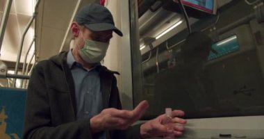 Tramvayda seyahat eden maskeli adam.