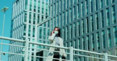 İş bölgesinde maskeli bir kadın duruyor.