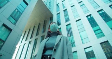 İş bölgesinde maskeli bir kadın duruyor.