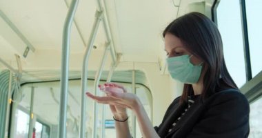 Tramvayda seyahat eden maskeli kadın.