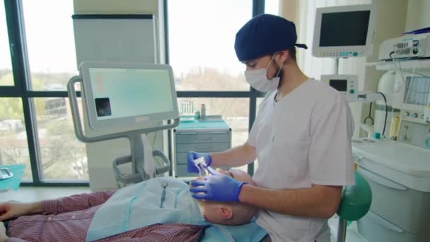 Стоматолог Готовит Пациента Процедуре — стоковое видео
