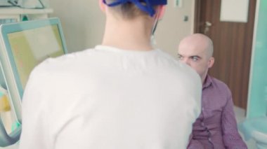 Dişçi, hastanın dişlerinin 3 boyutlu taramasını açıklıyor.