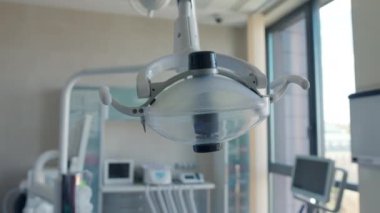 Kadın dişçi ofisinde elektrik lambasını açıp kapatıyor.