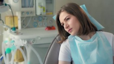 Hasta dişçi ofisinde oturuyor.