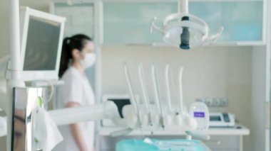 Diş hekiminde yüz maskesi takan kadın dişçi.