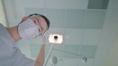 Yüz maskeleri ve yüz koruyucuları takan dişçi ve hemşire.