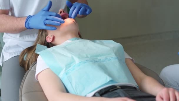 歯医者が患者の歯を調べる — ストック動画