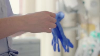 Dişçi dişçi muayenehanesinde cerrahi eldiven takıyor.