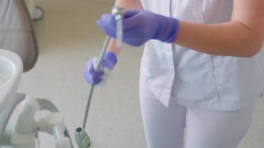 Kadın dişçi, dişçi muayenehanesinde dişçi temizlik ekipmanı.