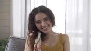 Kız gülüyor ve saçını düzeltiyor.