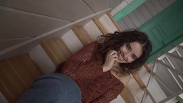 Cámara dinámica se mueve chica sonriendo sentado en las escaleras y riendo posando . — Vídeo de stock