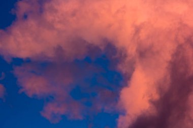 Gün batımında mavi gökyüzünün arka planında pembe bulutlar