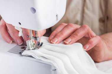 Annem COVID-19 'u önlemek için çocuklarının yüzüne bez bir maske dikiyor..