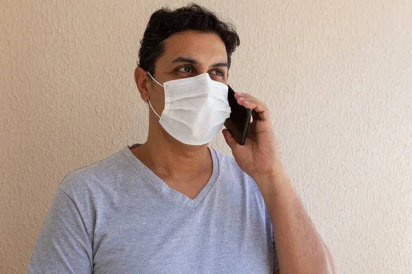 adult wearing disposable surgical mask with phone