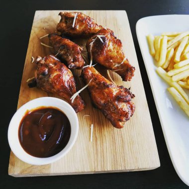 Kesme tahtasında servis edilen ızgara tavuk bacağı.