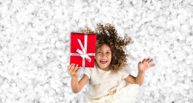 Kırmızı hediye. Parlak beyaz gümüş ışıkları arka planı kırmızı hediye kutusu Beyaz kurdele ile tutarak kıvırcık saçlı küçük bir beyaz beyaz kız resmi