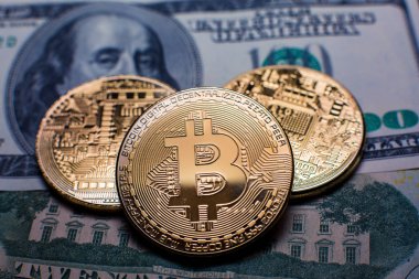 Bitcoin. Altın Bitcoins bir yüz dolarlık banknot üzerinde kapat
