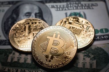 Bitcoin. Altın Bitcoins bir yüz dolarlık banknot üzerinde kapat