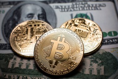 Bitcoin. Altın Bitcoins bir yüz dolarlık banknot üzerinde kapat