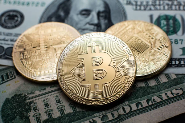 Bitcoin. Bitcoins de oro en un billete de cien dólares de cerca — Foto de Stock