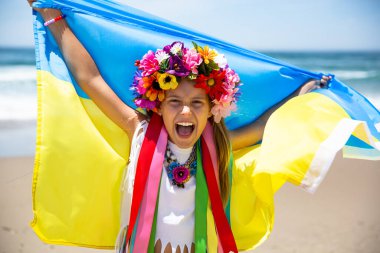 Young girl shouting with national flag of Ukraine above the head. Blue and yellow Ukrainian flag is a symbol of the country strength and independence clipart