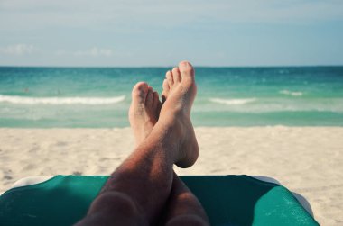 Küba, Varadero 'da plaj yatağında dinlenen genç bir adam..